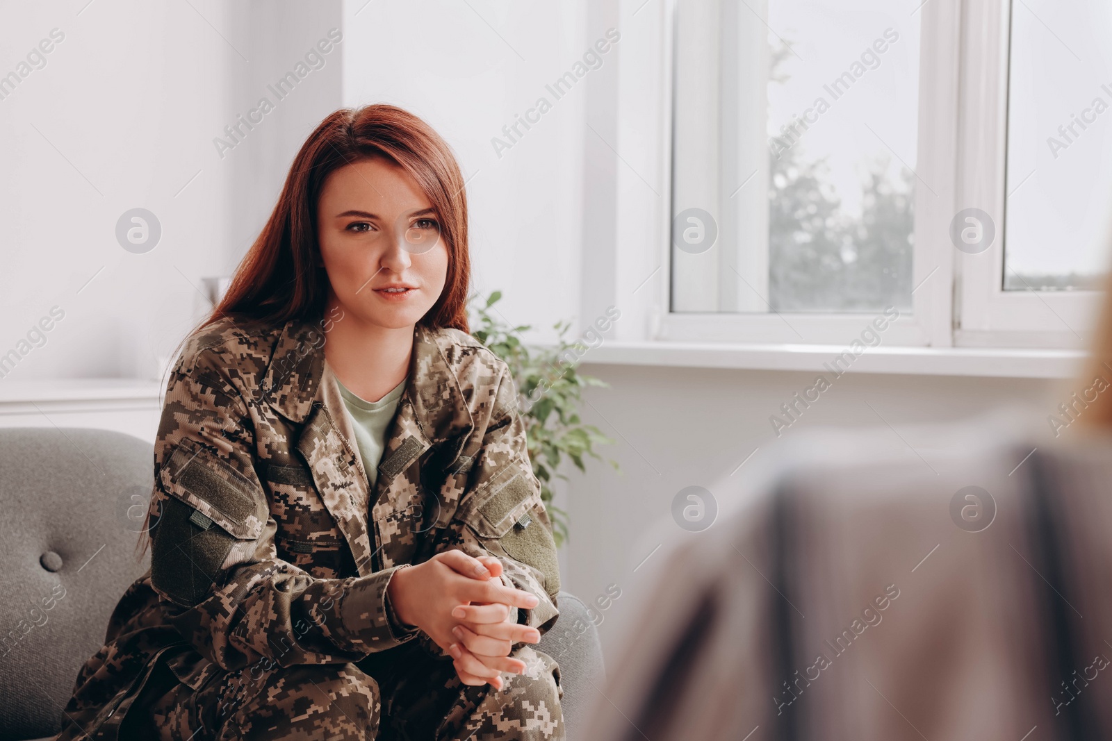 Photo of Female military officer talking with psychologist in office