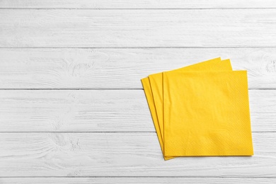 Photo of Clean napkins on wooden background, top view with space for text. Personal hygiene