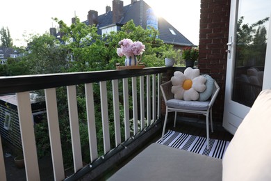 Photo of Different plants on railings and chair at cozy balcony outdoors