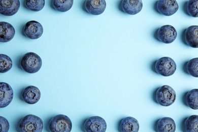 Photo of Frame of ripe blueberries on blue background, flat lay with space for text