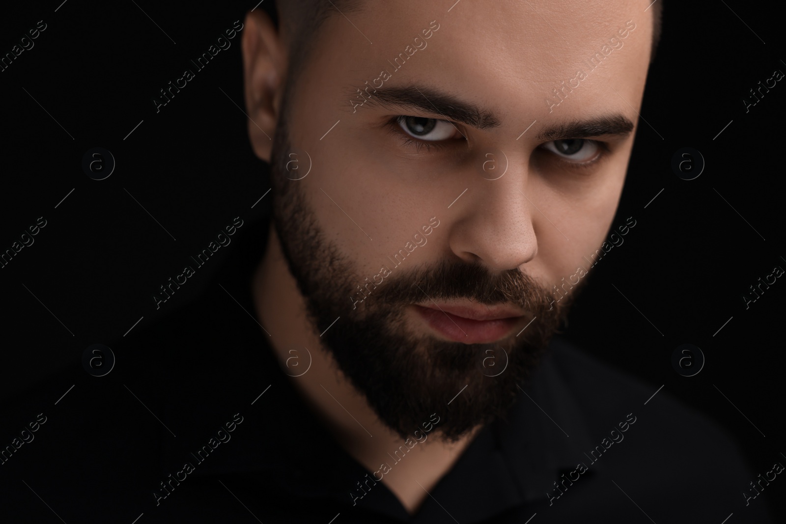 Photo of Evil eye. Man with scary eyes on black background