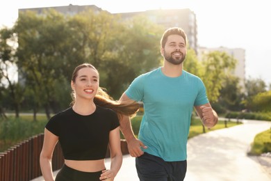 Healthy lifestyle. Happy couple running outdoors on sunny day