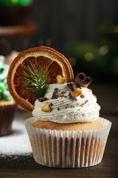 Photo of Beautifully decorated Christmas cupcake on wooden table, closeup