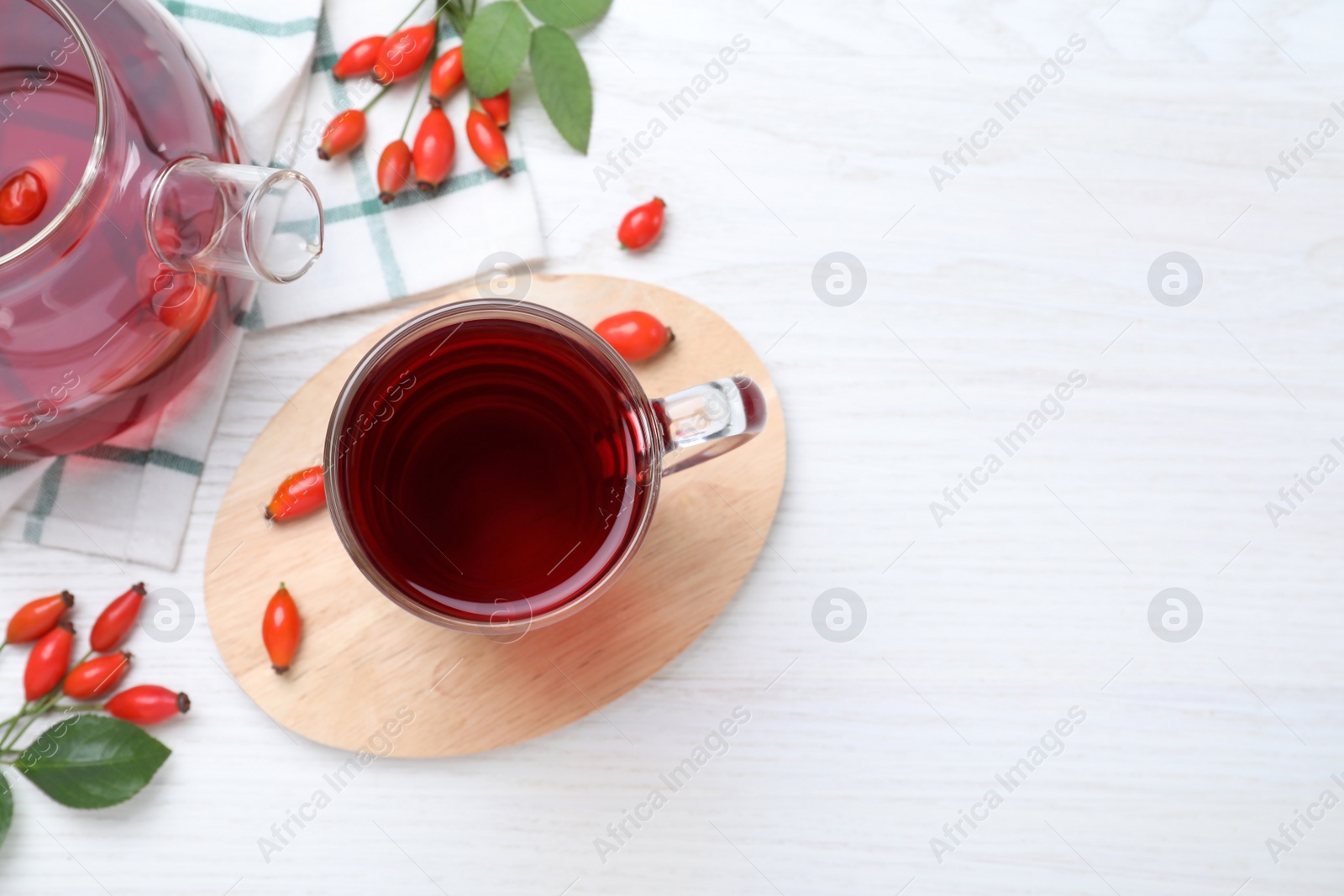 Photo of Flat lay composition with aromatic rose hip tea on white wooden table. Space for text
