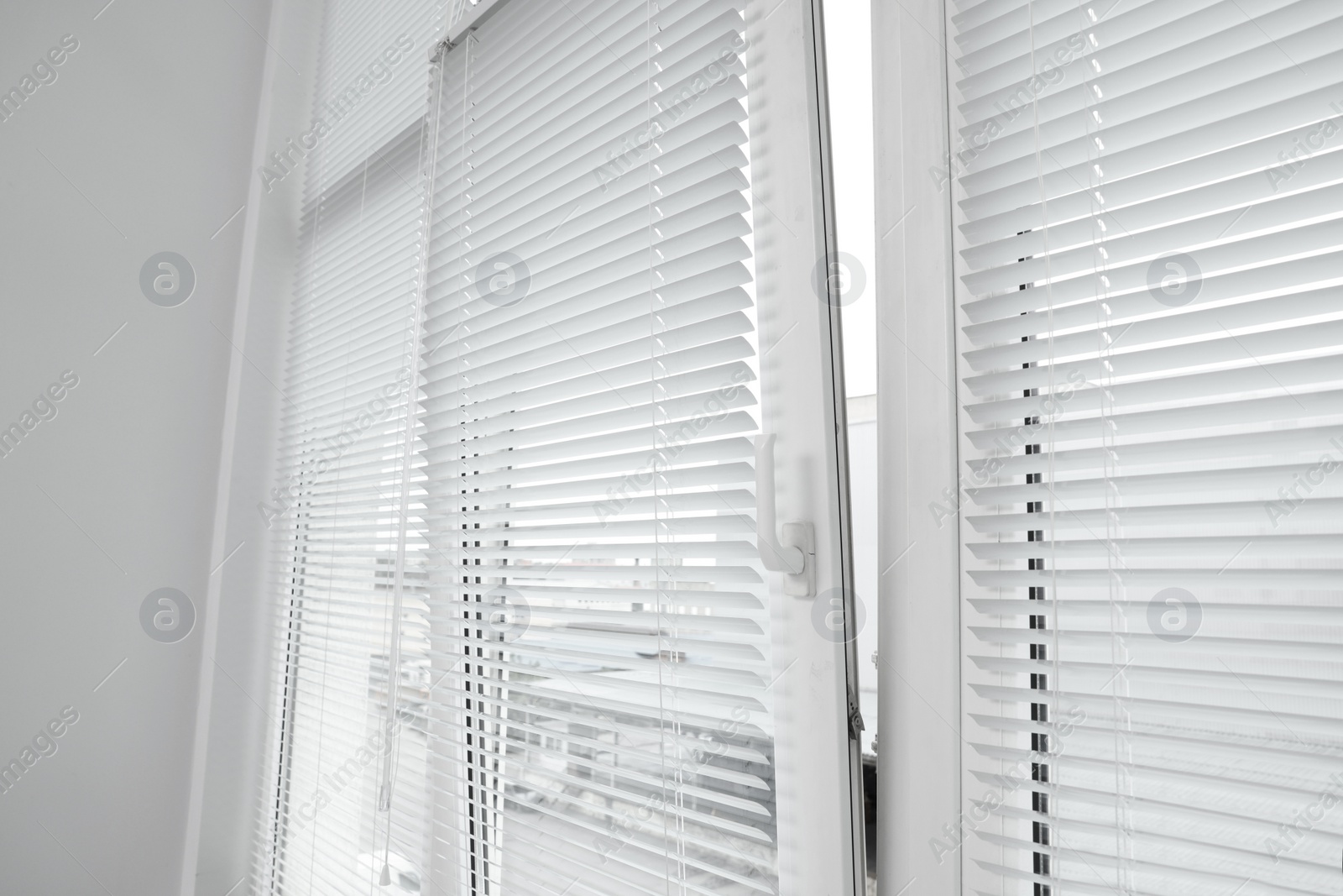 Photo of Stylish window with horizontal blinds in room