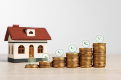 Image of Mortgage rate. Stacked coins, percent signs and model of house