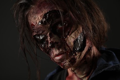 Photo of Scary zombie on dark background, closeup. Halloween monster