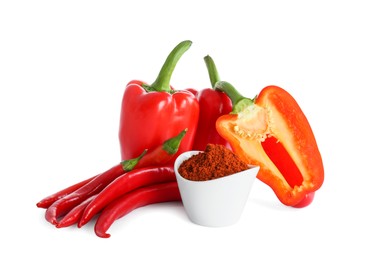 Fresh chili with bell peppers and bowl of paprika powder on white background