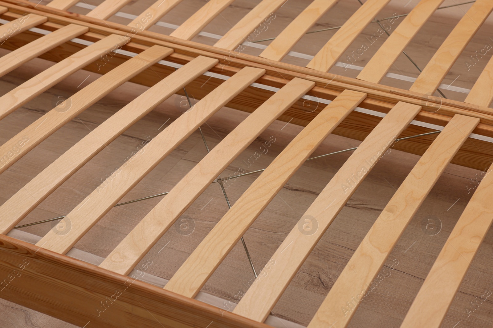 Photo of Wooden bed frame on floor, closeup view