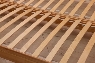 Photo of Wooden bed frame on floor, closeup view