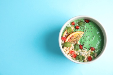 Photo of Bowl of spirulina smoothie on color background, top view with space for text
