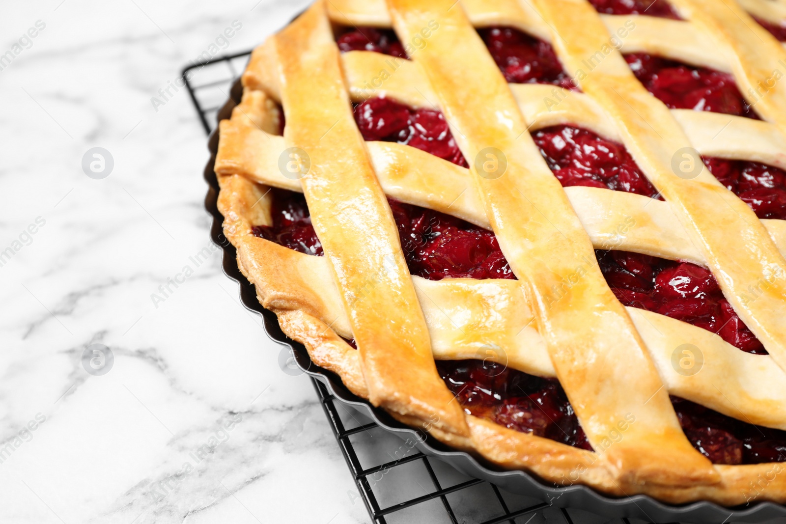 Photo of Delicious fresh cherry pie on white marble table, closeup