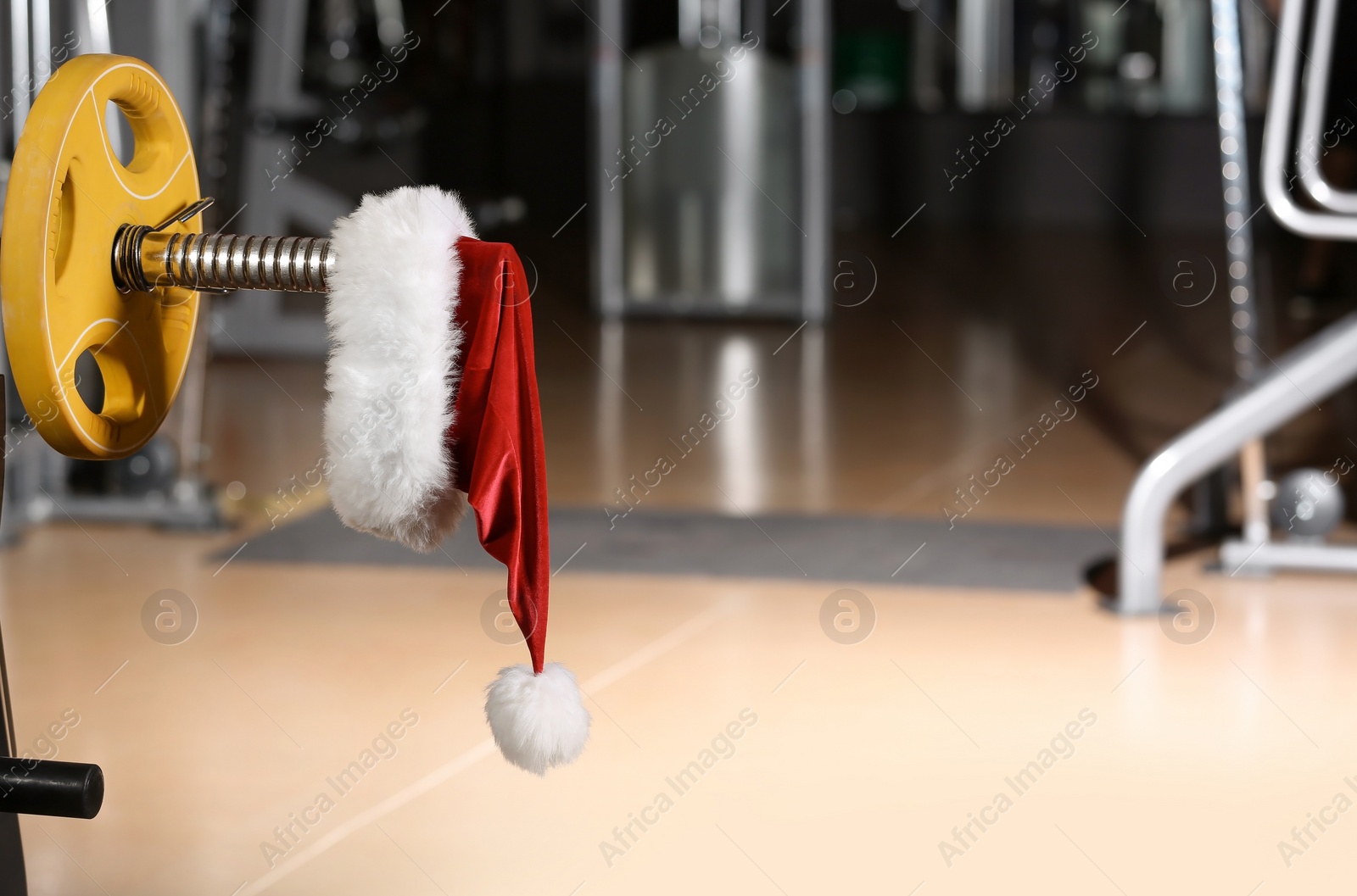 Photo of Santa Claus hat on barbell in gym