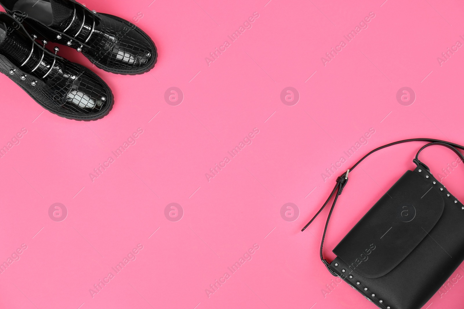 Photo of Pair of stylish ankle boots and bag on pink background, flat lay. Space for text