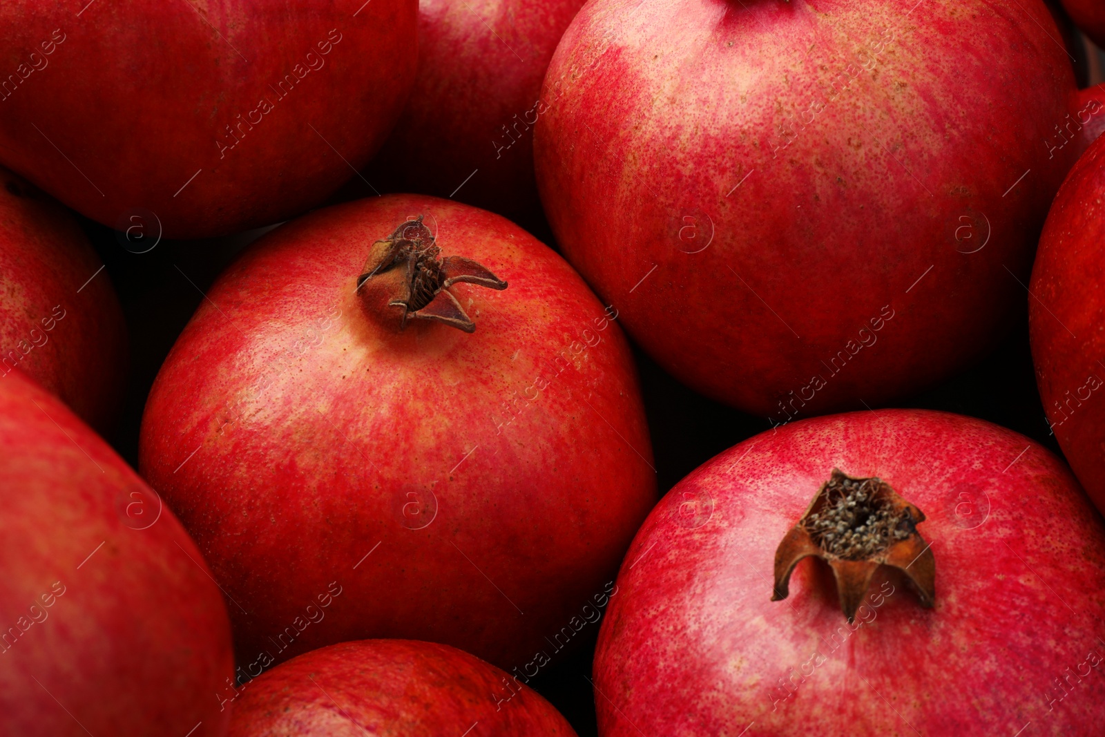 Photo of Many fresh ripe pomegranates as background, closeup