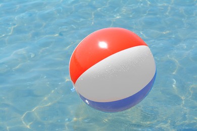 Photo of Colorful beach ball floating in sea on sunny day