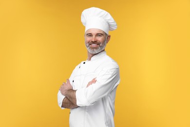 Happy chef in uniform on orange background