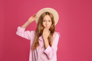 Photo of Portrait of emotional preteen girl in hat on pink background