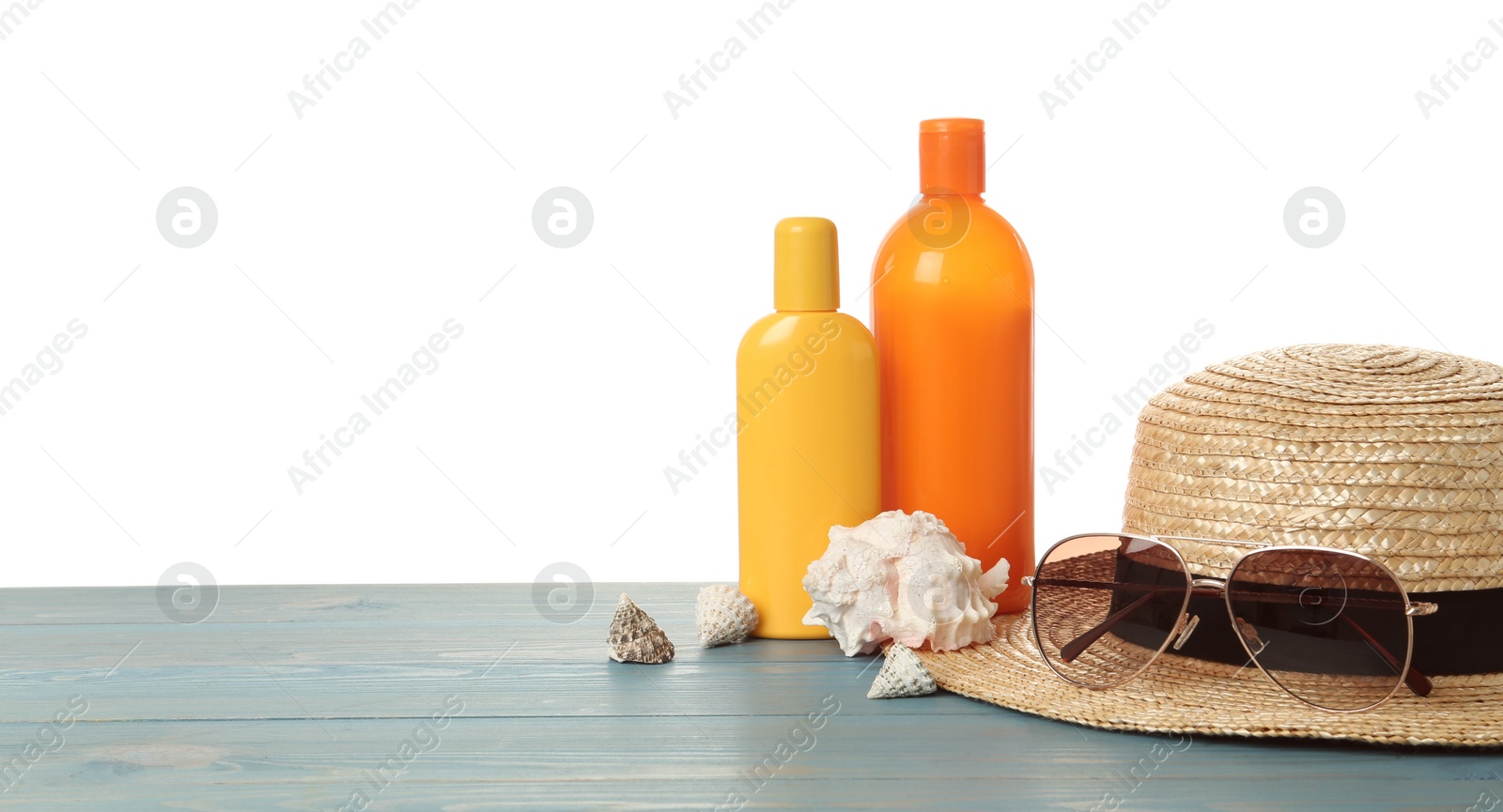 Photo of Sun protection products and beach accessories on blue wooden table. Space for text