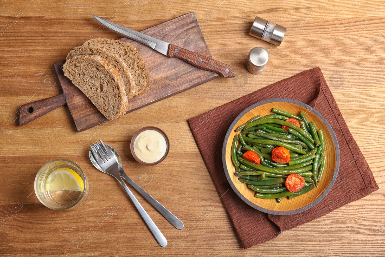 Photo of Tasty green bean dish served for dinner on wooden table