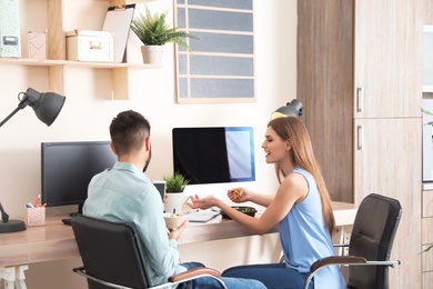 Photo of Office employees having lunch at workplace. Food delivery