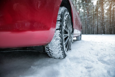 Car on snowy road, closeup. Space for text