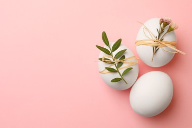Photo of Chicken eggs and natural decor on pink background, flat lay with space for text. Happy Easter