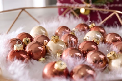 Photo of Beautiful Christmas baubles and feathers on tray, closeup