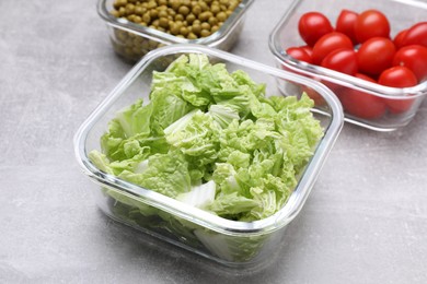 Glass containers with different fresh products on light grey table