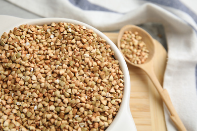 Photo of Bowl with green buckwheat on table, closeup