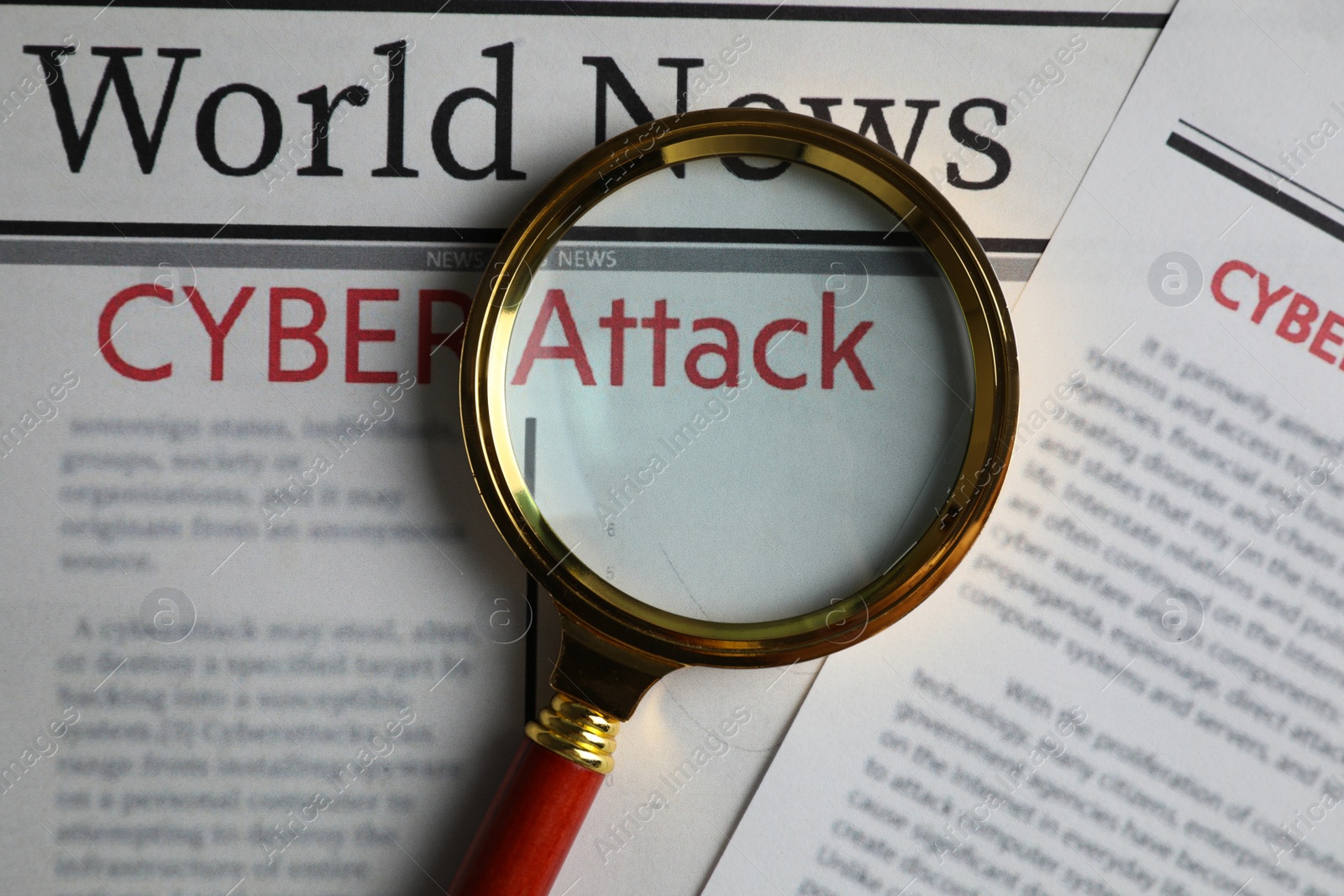 Photo of Newspaper with headline CYBER ATTACK and magnifying glass, top view