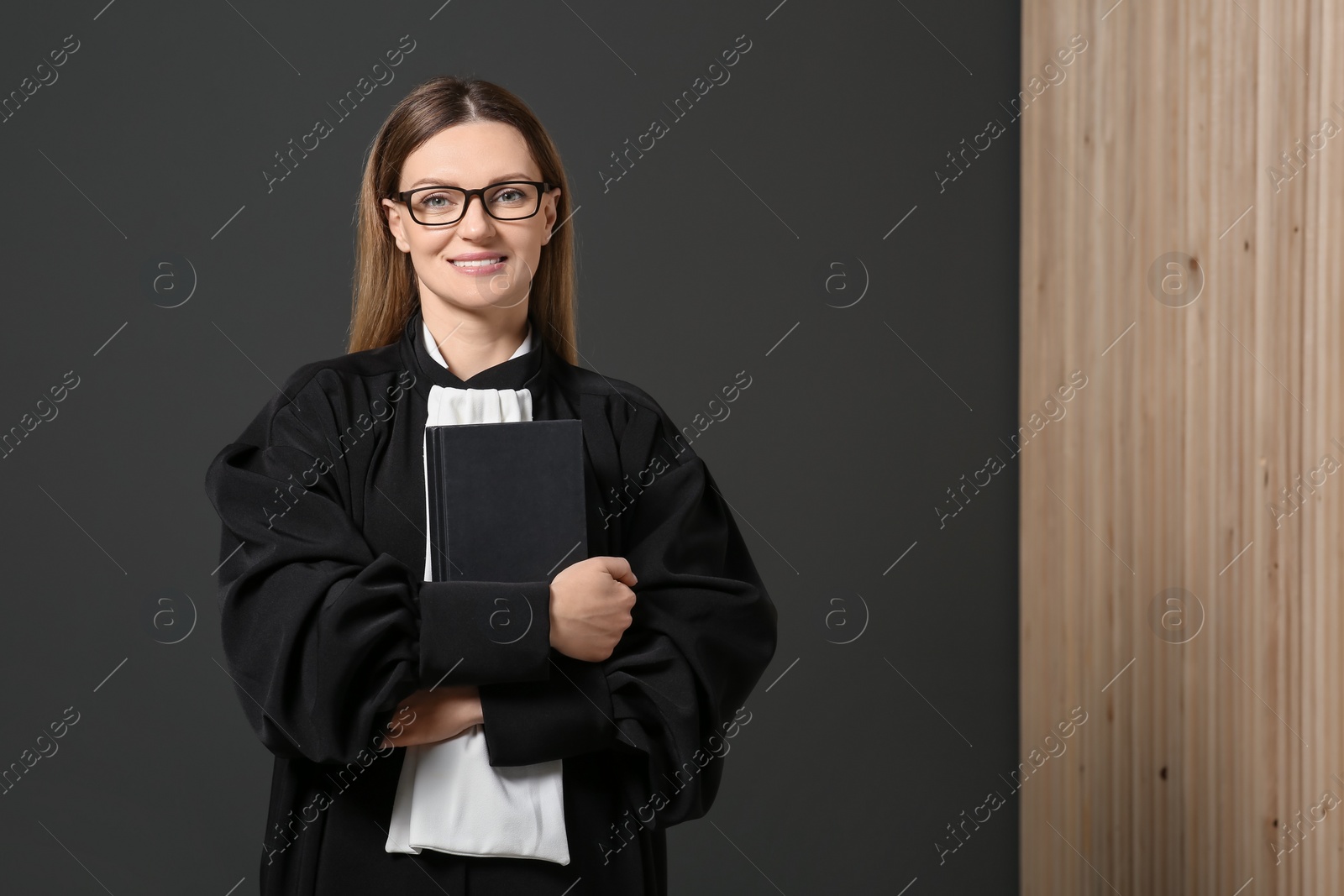 Photo of Portrait of smiling judge with book indoors. Space for text