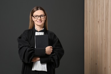 Photo of Portrait of smiling judge with book indoors. Space for text