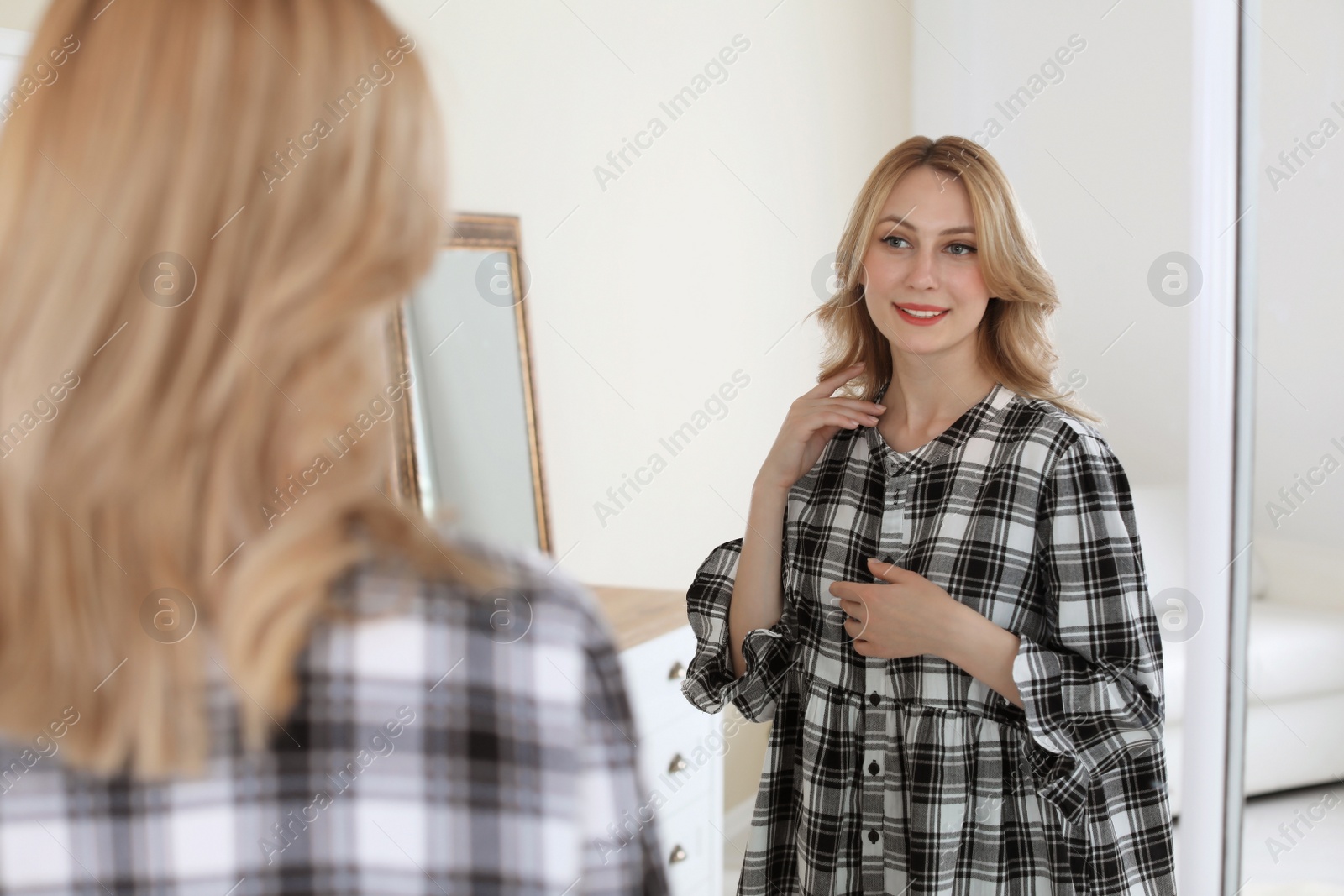 Photo of Young beautiful woman near mirror in makeup room