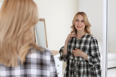 Young beautiful woman near mirror in makeup room