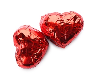 Photo of Heart shaped chocolate candies in red foil on white background, top view