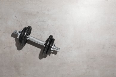 One barbell on grey floor, top view. Space for text