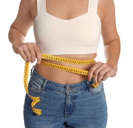 Photo of Woman measuring waist with tape on white background, closeup