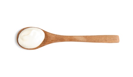 Photo of Wooden spoon with sour cream on white background, top view