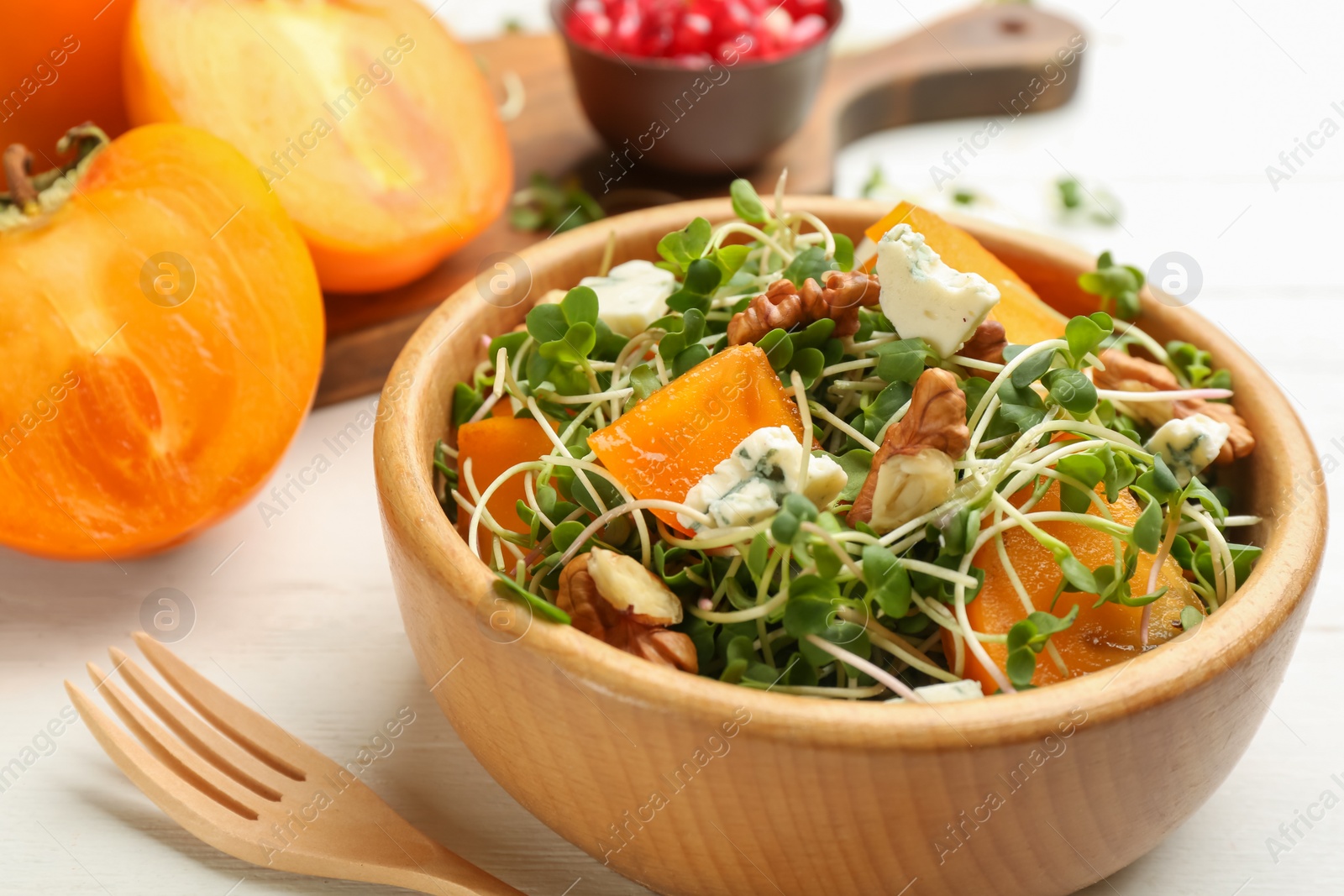 Photo of Delicious persimmon salad served on white table, closeup