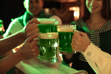 Photo of People with beer celebrating St Patrick's day in pub, closeup