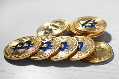 Golden bitcoins on light wooden table, closeup. Digital currency