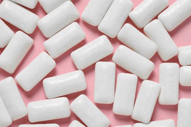 Photo of Tasty white chewing gums on pink background, flat lay