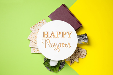 Image of Symbolic Passover items and card on color background, flat lay. Pesah celebration