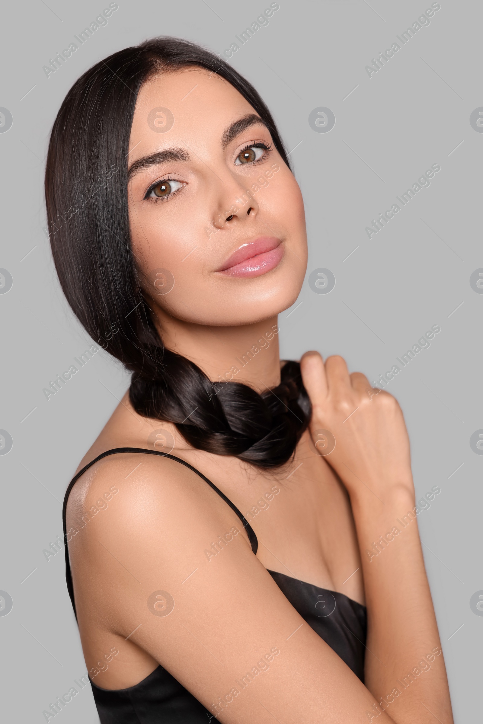 Photo of Portrait of beautiful young woman with healthy strong hair on light grey background