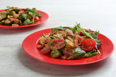 Photo of Salad with roasted brussels sprouts and bacon on white wooden table