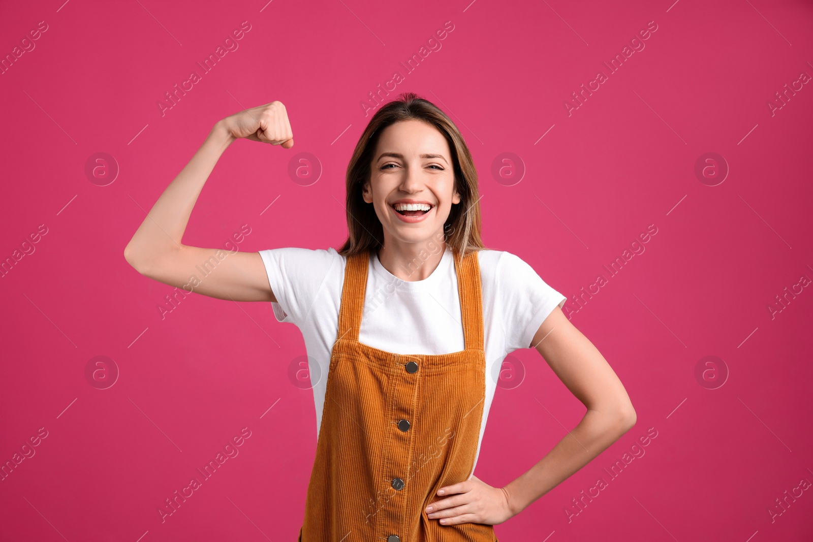 Photo of Strong woman as symbol of girl power on pink background. 8 March concept