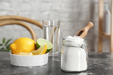 Photo of Jar with baking soda and lemons on table indoors