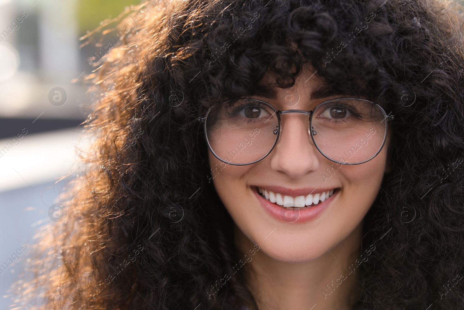 Photo of Portrait of beautiful woman in glasses on blurred background. Attractive lady smiling and looking into camera