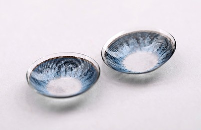 Photo of Two blue contact lenses on white background